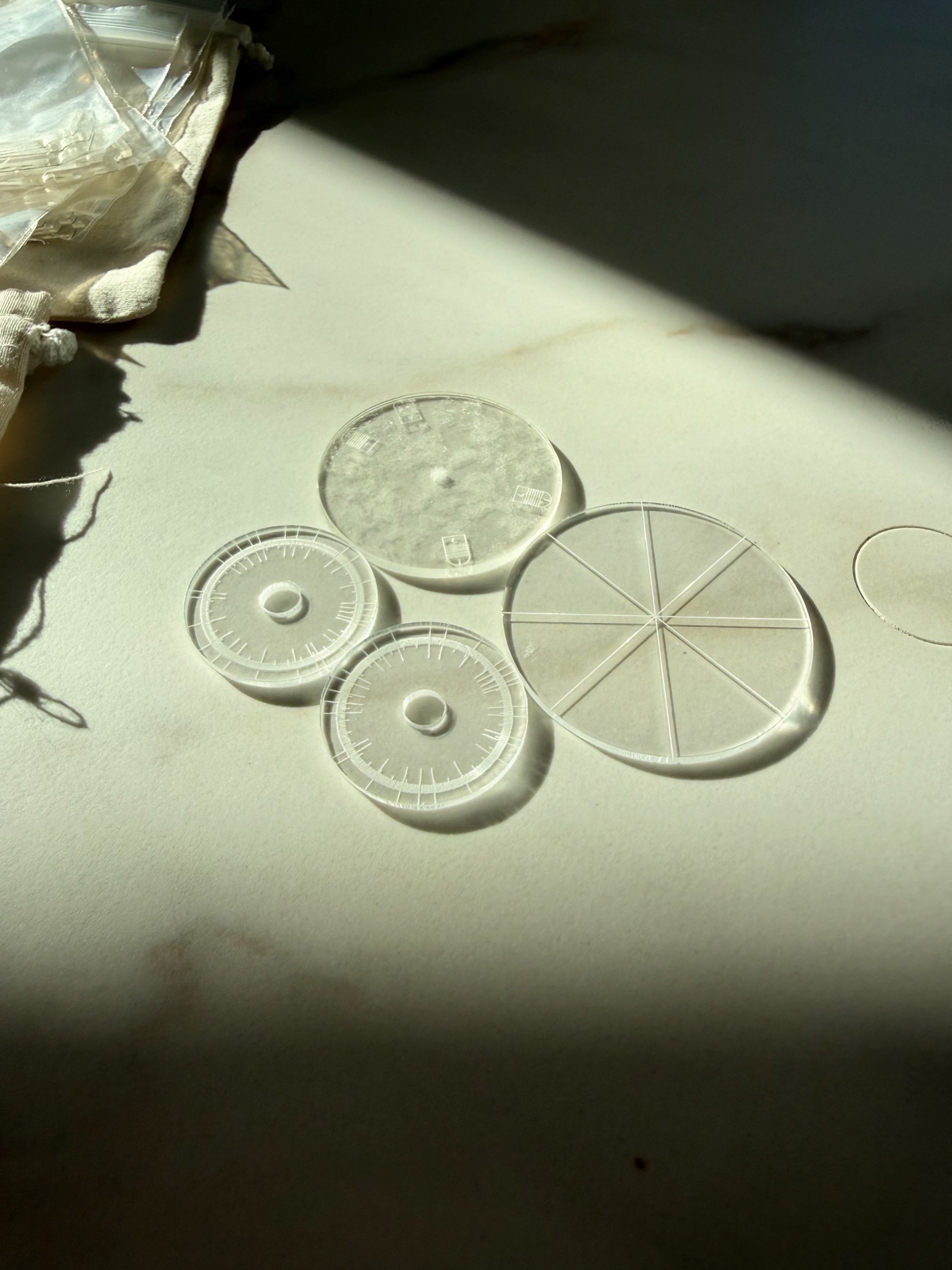 Clear geometric tools laid out on marble in a band of morning sun